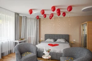 Pokoj s vířivkou na fotce je postel s romantickou výzdobou a balónky u stropu