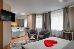 Pokoj s vířivkou na fotce je postel s romantickou výzdobou a vířivka se zrcadli